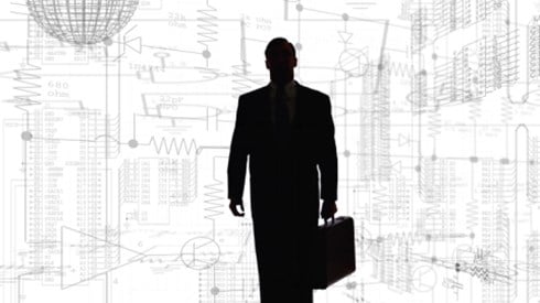 A silhouette of a businessman standing and holding a briefcase against a white background filled with gray technical drawings