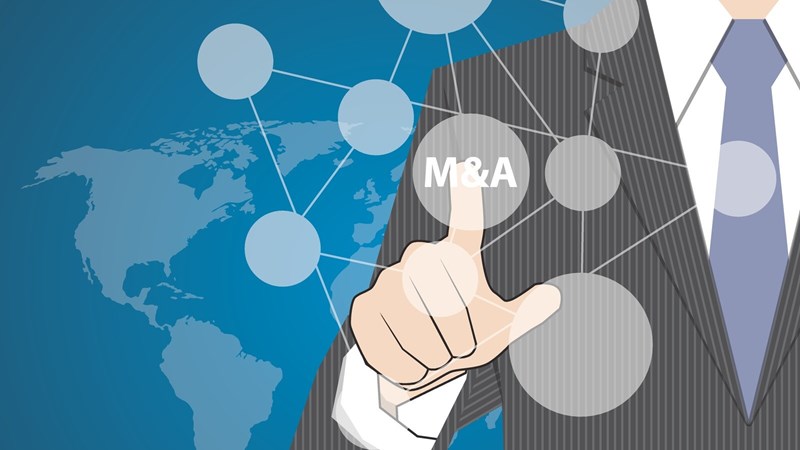 Businessman pointing at M-and-A button on a bubble chart with a global map in background