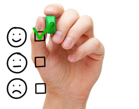 Hand Checking Off A Happy Face From A Faces List