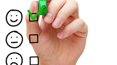 Hand Checking Off A Happy Face From A Faces List