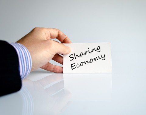 Hand holding paper with sharing economy text