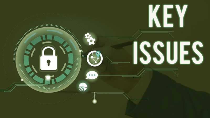 Businessperson hand in murky background writing while padlock and other icons indicating critical topics float with words KEY ISSUES