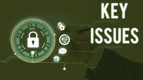 Businessperson hand in murky background writing while padlock and other icons indicating critical topics float with words KEY ISSUES