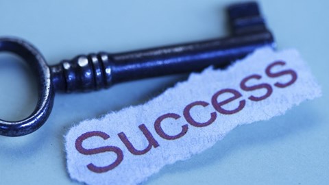 Old-fashioned key with a note reading success