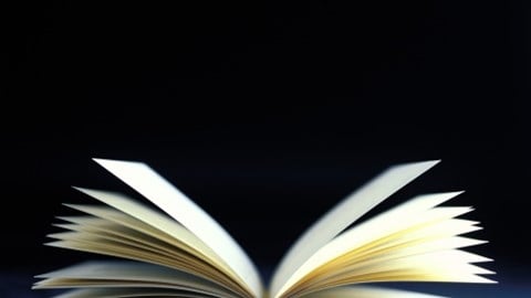 An open bound book with pages fanning upward