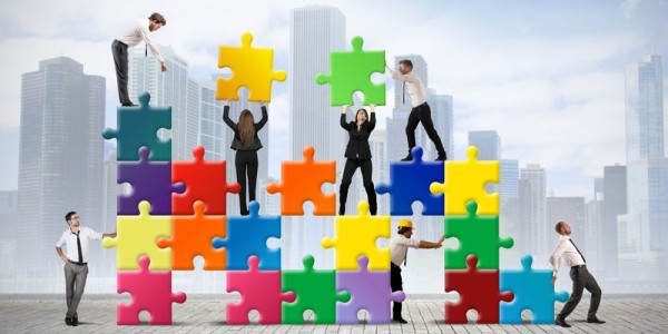 People moving colorful vertifcal puzzle pieces with buildings in the background