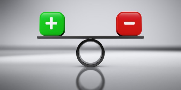 Balance board with a green cube marked with a plus sign on the left and a red cube marked with a minus sign on the right