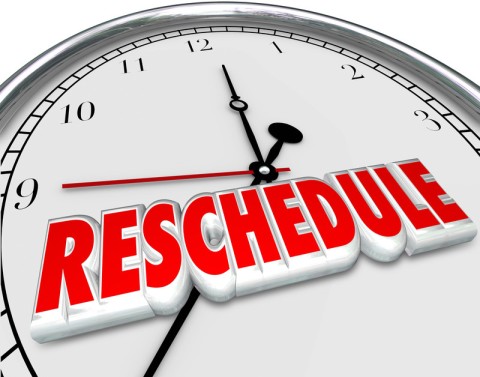 The top half of a clock with the word reschedule written on it