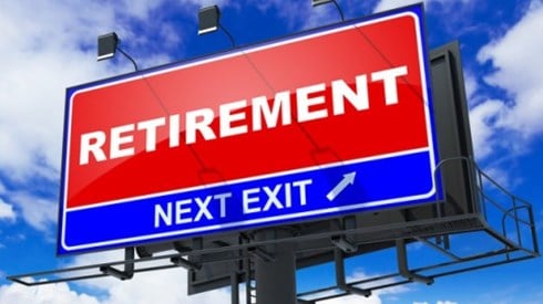 Highway sign of a red rectangle with the word RETIREMENT and below a smaller rectangle with the words NEXT EXIT and an arrow