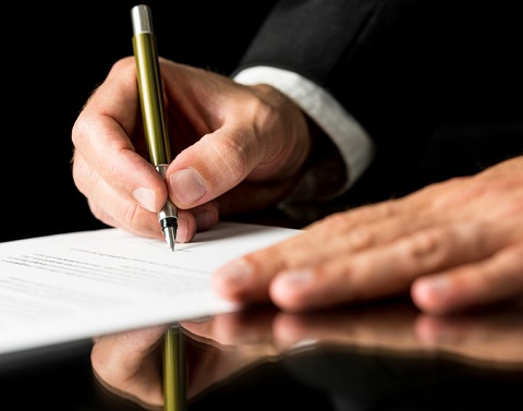 A businessman is signing a document.