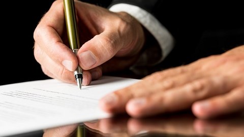 A businessman is signing a document.