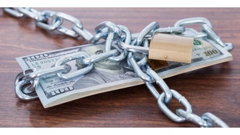 Stack of hundred dollar bills wrapped in chains and padlocked