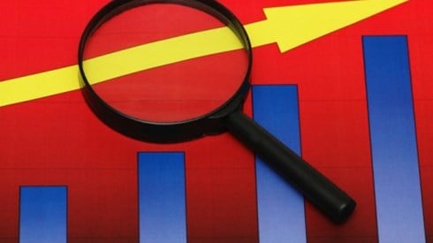 A magnifying glass focuses on part of an arrow that is following the growth of 4 graph bars ascending in value