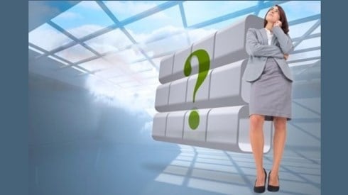 Woman standing and thinking in a room with a large green question mark and blue sky and clouds filtering through the skylight