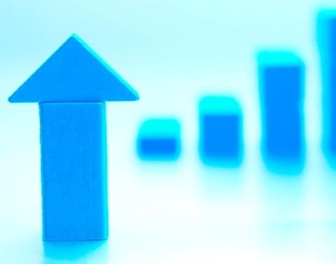 Blue upward arrow with blurred blue graph in the background