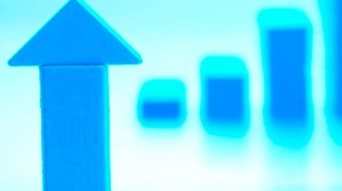 Blue upward arrow with blurred blue graph in the background