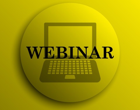 Yellow pinback button with a laptop silhouette in the background and the word WEBINAR in the foreground