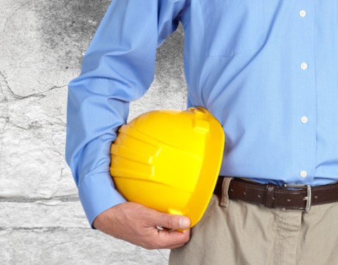 Businessman holding yellow hard hat