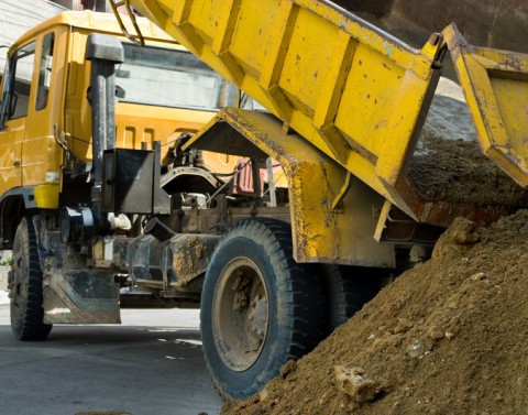 Construction dump truck unloading sand
