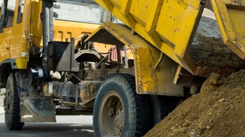 Construction dump truck unloading sand