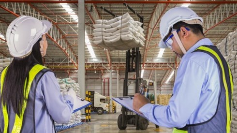 Warehouse Supervisors wearing Hardhats and Reflective Vests Monitor Forklift Safety Using Checklists