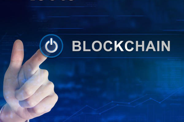 Finger selecting blockchain power button with blue digital background