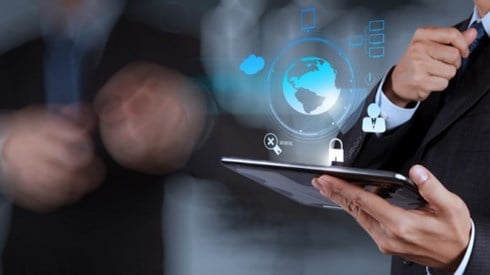 Businessman holding tablet emitting a blue hologram of earth with security icons