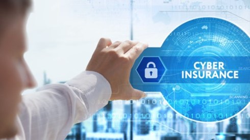 Man holding virtual blue safe with lock icon and dial and the words CYBER INSURANCE in glass above a desk in an office