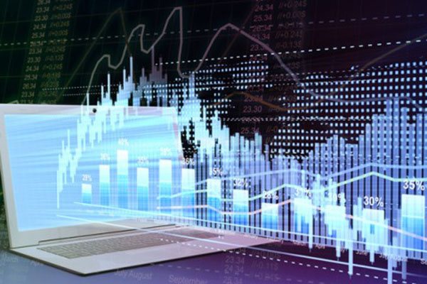 A laptop screen emits data in different formats while the background shows stock market board and a silhouette of world map