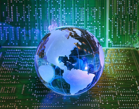 A blue glass globe sitting on a green circuit board with a green circuit board in the background