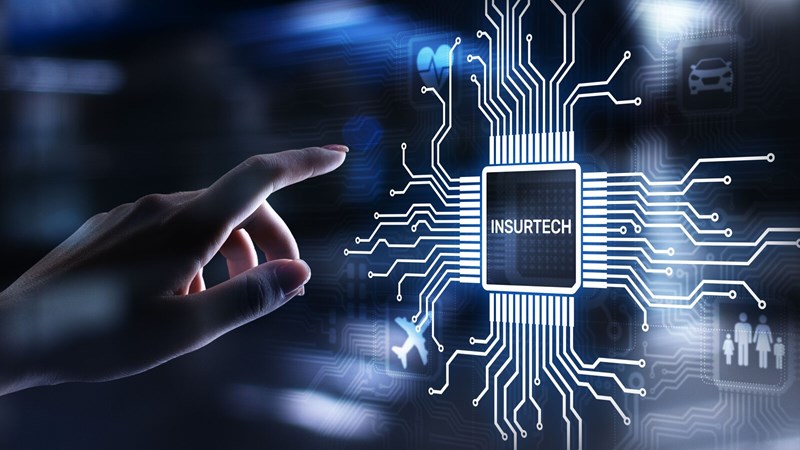 Hand reaching out to touch virtual button in the shape of a computer chip that reads "InsurTech"