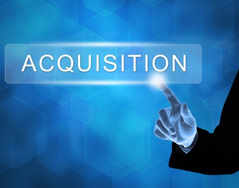 A businessman touches and activates a giant button marked as ACQUISITION