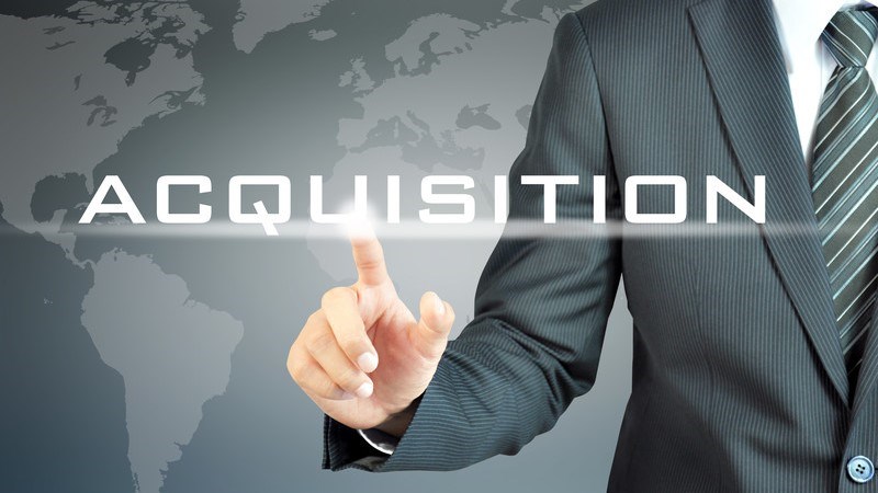 Finger touching the word Acquisition on virtual screen with global map in background