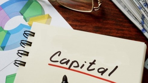 Capital Notebook with graphs, eyeglasses, and a stack of money