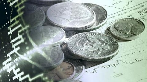 Photo of US coins on top of stock trading documents in green