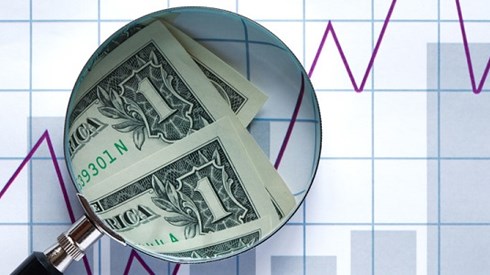 Magnifying Glass Looking At Dollar Bills On Bar Chart