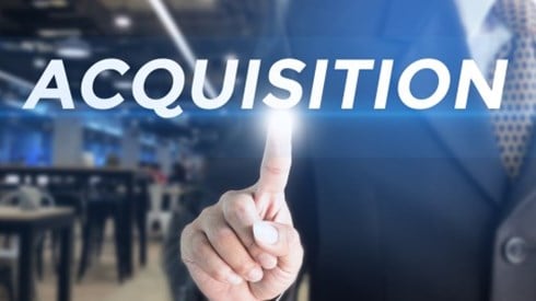Businessman pointing with index finger to floating text of the word Acquisition