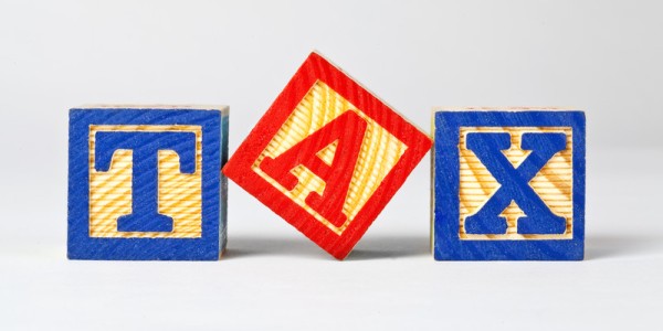 Wooden building blocks spelling out the words TAX in blue and red letters