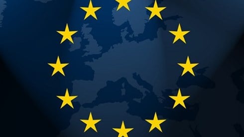 12 yellow stars in a circle on top of a map of the European continent on a dark blue wavy material