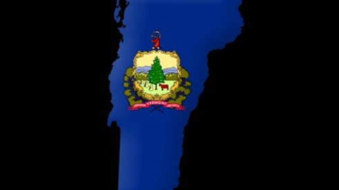 State of Vermont colored in solid blue with the Vermont seal in the middle of the state on a black background
