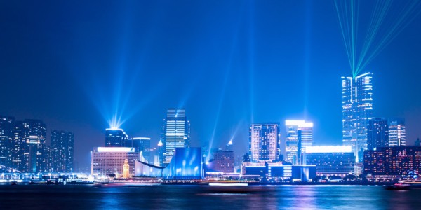 Hong Kong night skyline with spotlight shining from the tops of several buildings