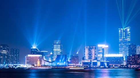 Hong Kong night skyline with spotlight shining from the tops of several buildings