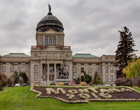 Montana capitol building on beautiful green landscaped grounds with cloudy skies in background