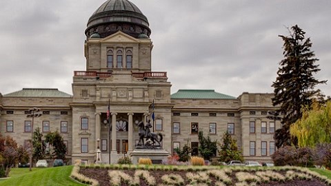 Montana capitol building on beautiful green landscaped grounds with cloudy skies in background