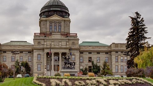 Montana capitol building on beautiful green landscaped grounds with cloudy skies in background