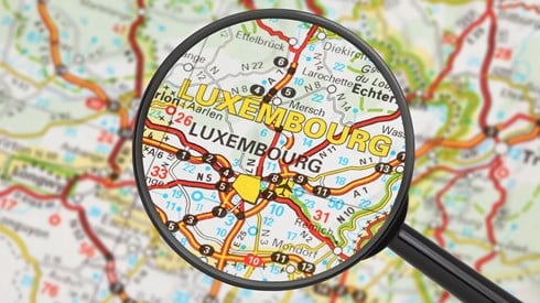 Magnifying glass zooming in on Luxembourg