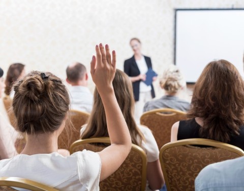 College Student Raising Hand at Conference