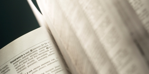An open dictionary with the insurance definition showing 