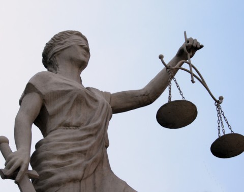Statue of blindfolded woman holding scale and sword