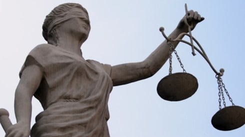 Statue of blindfolded woman holding scale and sword